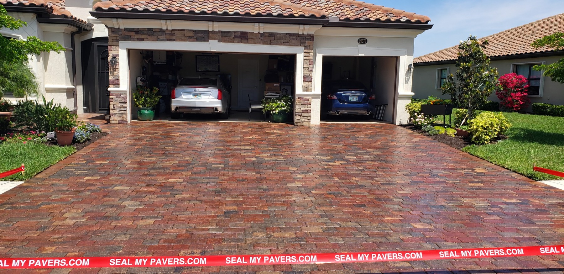 Warm paver tones across a driveway with two open garages