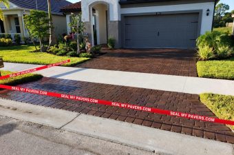 Paver driveway at 11697 Renaissance Drive with neatly straightened red Seal My Pavers barrier tape.