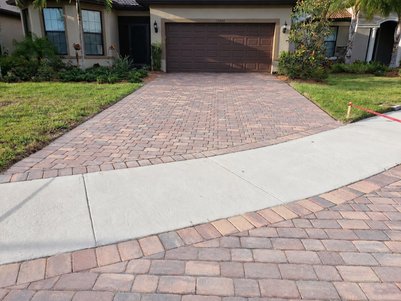 Dry, matte driveway pavers at Ricci Street in IslandWalk, Venice, shown in the unfinished comparison.