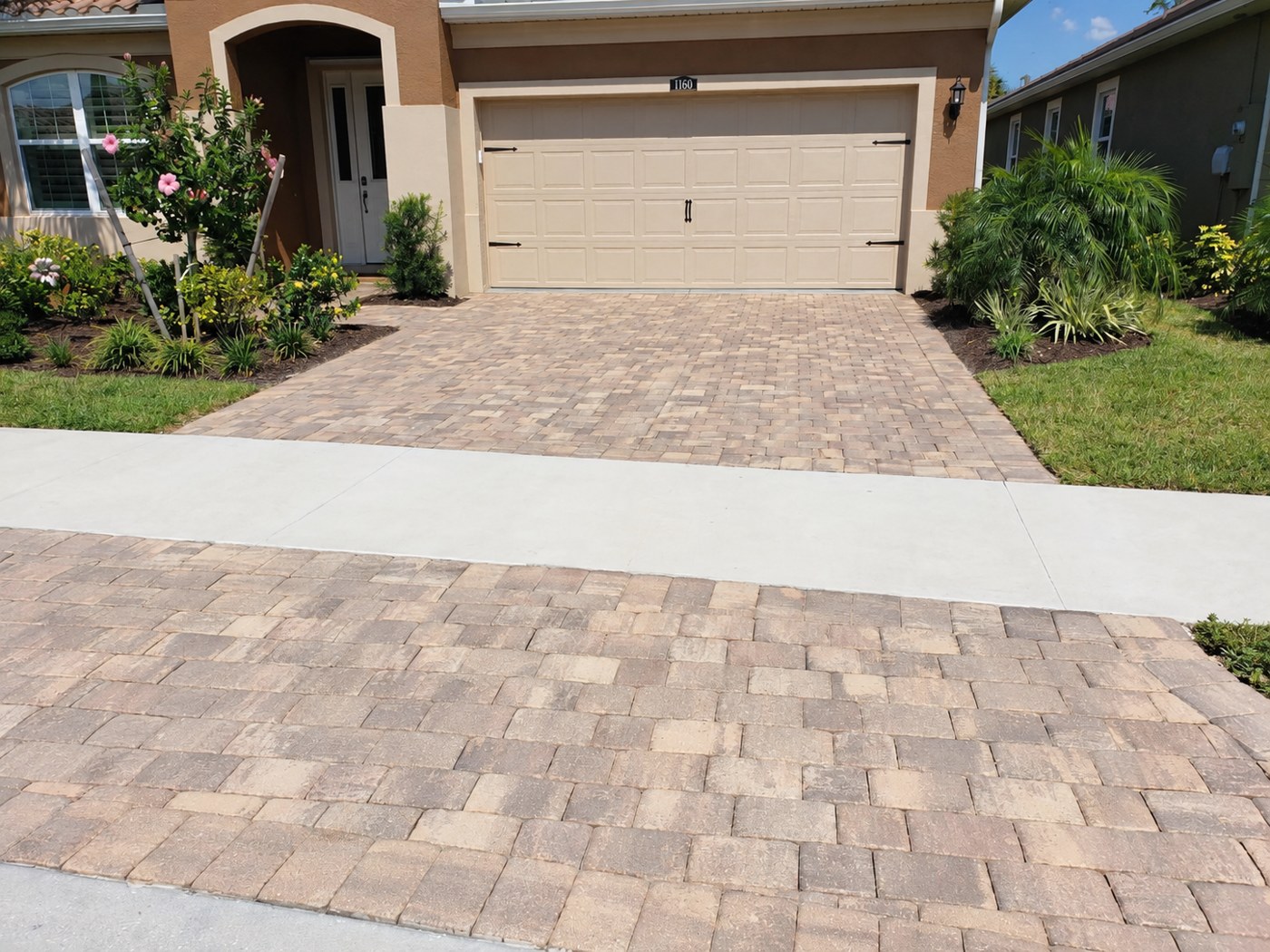 Dry, matte driveway pavers at Renaissance Boulevard in West Villages, Venice, shown in the unfinished comparison.