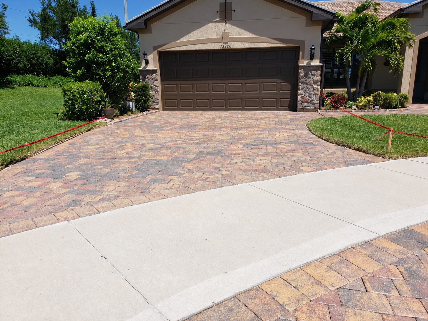 Dry, matte driveway pavers at Umbria Street in IslandWalk, Venice, shown in the unfinished comparison.