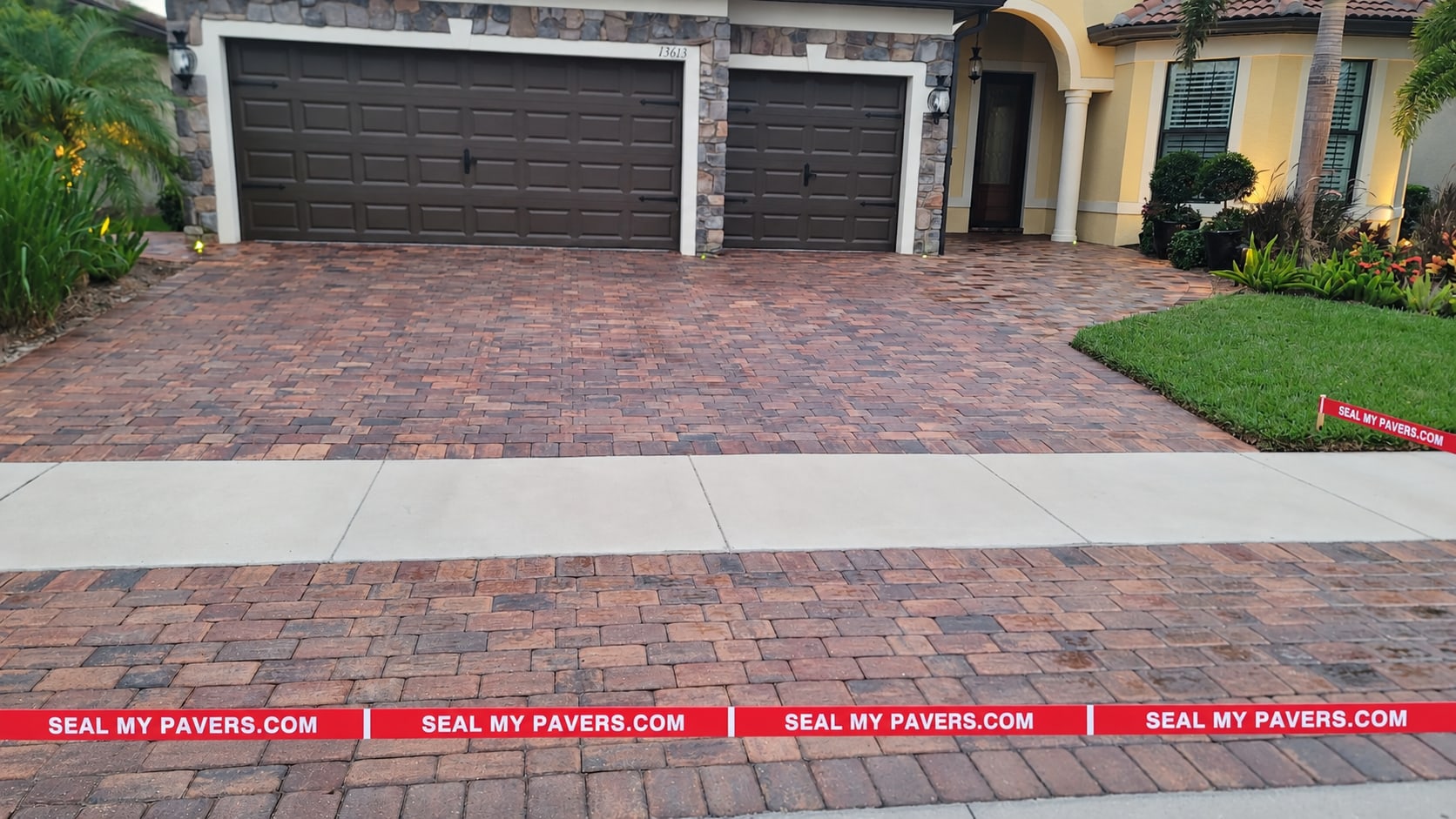 Venice paver driveway cleaned and sealed by Seal My Pavers, with straight red branded barrier tape